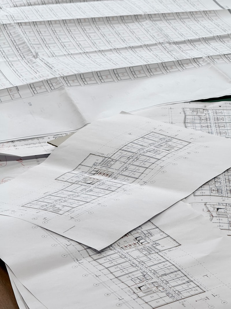 Architectural floor plans spread across a table during space planning